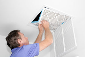 Man Removing Dirty Air Filter - Consign Living
